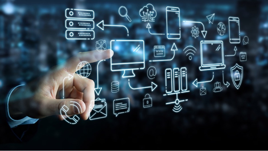 Aerial view of a large telecommunications tower with multiple antennas and dishes against a clear blue sky